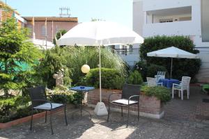 a patio with a table and chairs and an umbrella at Villa Corallo in Grado