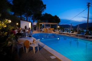 a group of people sitting around a swimming pool at night at Residence Vacanza Mare in Campo nell'Elba