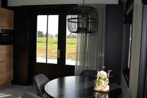 a dining room with a table and chairs and a window at Woudmeer 1 in Dirkshorn