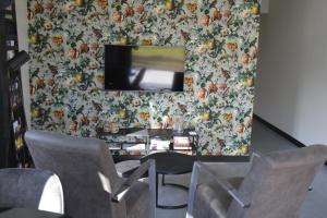 a room with chairs and a tv on a wall at Woudmeer 1 in Dirkshorn