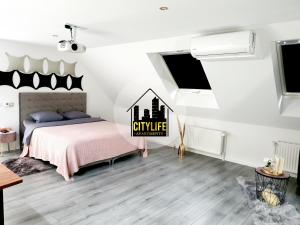 een slaapkamer met een bed met een roze deken bij CITYLIFE Apartments Osnabrück mit E-Ladesäule in Osnabrück