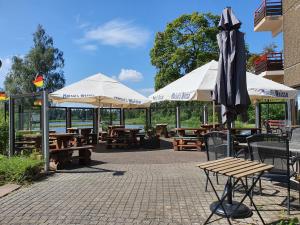 um pátio exterior com mesas, guarda-sóis e bancos em Harz Relax - Vier Jahreszeiten em Hahnenklee-Bockswiese