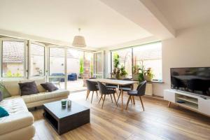 EttendorfSpacieux Appartement 3 CHBR,,Terrasse,Adapté Bébé的客厅里有一张沙发、一张桌子和几把椅子