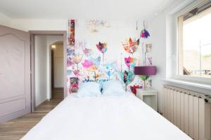 EttendorfSpacieux Appartement 3 CHBR,,Terrasse,Adapté Bébé的一间卧室配有一张白色大床和色彩缤纷的墙壁