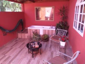 um quarto vermelho com uma banheira, uma mesa e cadeiras em Pousada Princesa Do Vale em Belo Vale