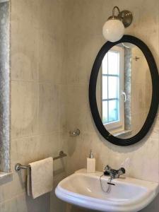 een badkamer met een wastafel en een spiegel bij Apartamento céntrico en Finisterre in Fisterra