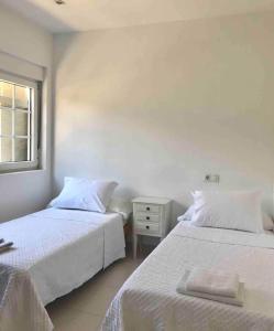 een slaapkamer met 2 bedden en een raam bij Apartamento céntrico en Finisterre in Fisterra