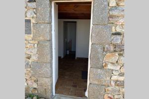 un pasillo que conduce a una habitación con una pared de piedra en SCIOTOT - Bord de mer - La petite maison, en Les Pieux