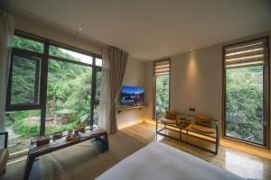 张家界Zhangjiajie Rock language art hotel-Free pick up service的一间带大窗户的卧室和一间客厅