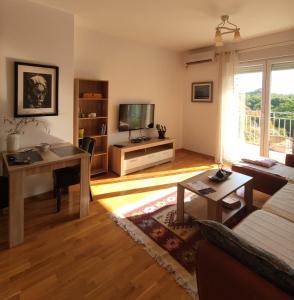 een woonkamer met een bank en een tafel bij Apartment Anagastum in Nikšić