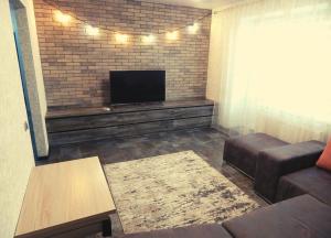 Una sala de estar con un sofá y un televisor de pantalla plana. en Комфортні Апартаменти біля Фентезі Парка, en Uman