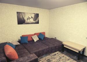 Una sala de estar con un sofá marrón y una mesa. en Комфортні Апартаменти біля Фентезі Парка, en Uman