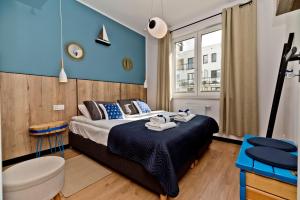 a bedroom with a bed and a blue wall at BlueApart Apartamenty Hotelowe Nexo in Puck