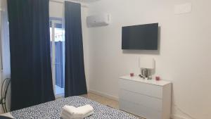 a bedroom with a bed and a tv on a wall at YTHA HOUSSE ROMA CENTRO in Rome