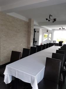 a large white table with black chairs in a room at Vila Eduard in Fundata