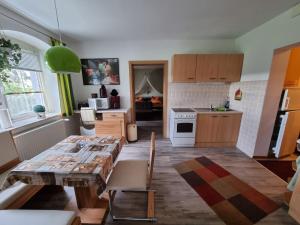 cocina y sala de estar con mesa de madera en Ferienwohnung Reinhardt Steinhübel en Kurort Seiffen