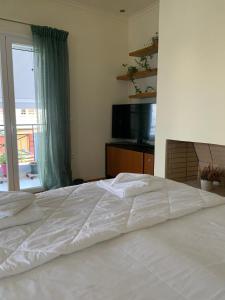 a white bed in a bedroom with a window at Zenmar in Zakynthos Town