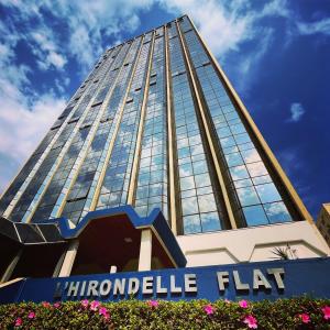 a tall building with a sign in front of it at L'Hirondelle Flat Service in Campinas