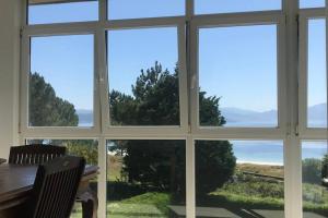 una ventana con vistas al océano a través de ella en Apartamento primera línea de playa, en Finisterre