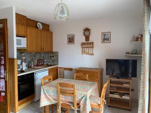 a small kitchen with a table and a television at Studio Embrun à 10 mn à pied plan d eau de 2 à 4 personnes sans linge de lit ni serviettes situé 3 chemin de chadenas in Embrun