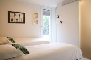 a bedroom with two beds and a window at Rietreiger luxe vakantielodge in Friesland - 2 badkamers in Grou