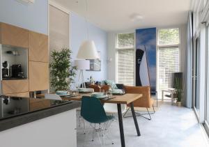 eine Küche und ein Esszimmer mit einem Tisch und Stühlen in der Unterkunft Rietreiger luxe vakantielodge in Friesland - 2 badkamers in Grou
