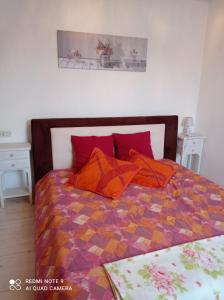 カステッロ・テジーノにあるVacanze In Tesinoのベッドルーム1室(オレンジ色の枕が付いたベッド1台付)