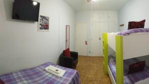 a bedroom with two bunk beds and a flat screen tv at Pensión Pamplonabeds in Pamplona