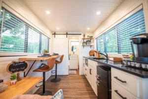 a kitchen with a counter and some windows at NEW The Brazos-Tiny Home 12 Min to downtown in Bellmead