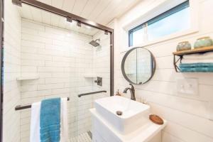 Baño blanco con lavabo y espejo en NEW The Brazos-Tiny Home 12 Min to downtown, en Bellmead