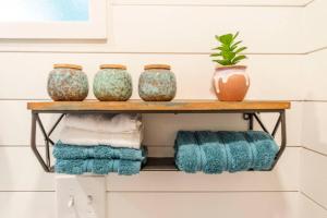 a shelf with three vases and towels on it at NEW The Brazos-Tiny Home 12 Min to downtown in Bellmead