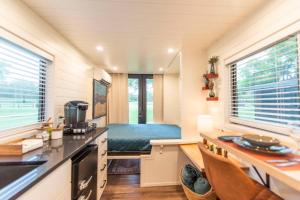 a small kitchen with a bed in a tiny house at NEW The Brazos-Tiny Home 12 Min to downtown in Bellmead