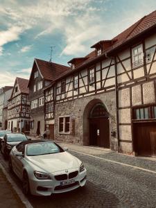 een witte auto geparkeerd voor een gebouw bij Zum Ewigen Rath in Mühlhausen