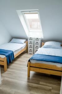 two beds in a room with a window at Haus Sandglöckchen in Greetsiel