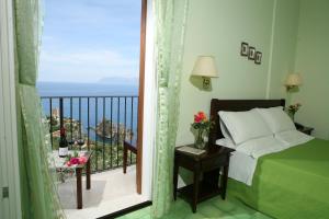 a bedroom with a view of the ocean from a balcony at Torre Bennistra in Scopello