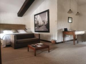 Hotel Canaria في Santeagueda: غرفة نوم بسرير واريكة وبيانو