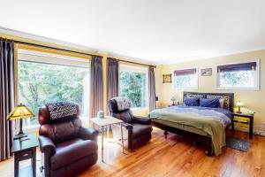 a bedroom with a bed and a couch and chairs at The Potter House in Eugene