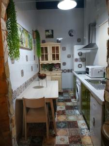 a kitchen with a table and a sink at Tu rincón sevillano in Seville