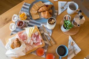 a wooden table with a plate of breakfast foods and coffee at Encanto Agriturismo & Private SPA in Visogliano