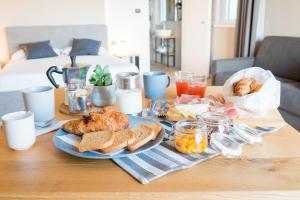 a table with a plate of bread and pastries on it at Encanto Agriturismo & Private SPA in Visogliano