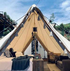 Tienda grande con cama y sofá en Asis Glamping 1, en Guatapé