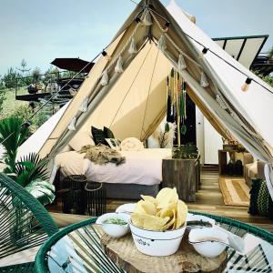 a tent with a bed and bowls of food on a table at Asis Glamping 1 in Guatapé