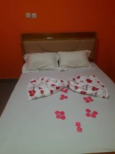 a bed with a bow tie on top of it at NPANGOU APPART in Kribi