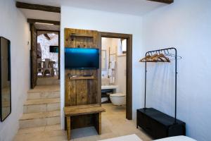 salon z telewizorem i łazienką w obiekcie Il Trullo della Rondinina w Alberobello