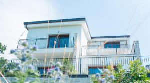 a white house with balconies and flowers in front of it at Encanto Agriturismo & Private SPA in Visogliano