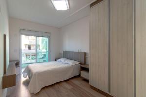 sypialnia z łóżkiem i dużym oknem w obiekcie Aluguel Apartamento 3 quartos vista mar Bombas SC w mieście Bombinhas