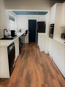 a kitchen with a counter and a wooden floor at Henbury House in Bristol