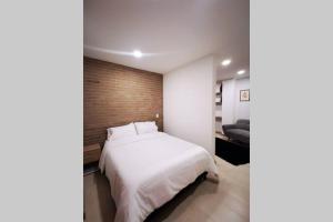 1 dormitorio con cama blanca y pared de ladrillo en Apartamento exclusivo en Manizales-Gran ubicación!, en Manizales