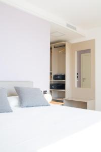 a bedroom with a white bed and a mirror at Encanto Agriturismo & Private SPA in Visogliano