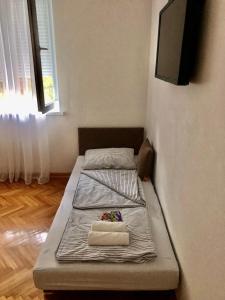 two beds in a room with a tv on the wall at Apartment Bregovi in Trebinje